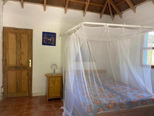 Mar LodjにあるBazouk Du Saloum Ecolodgeのベッドルーム(蚊帳付きのベッド付)