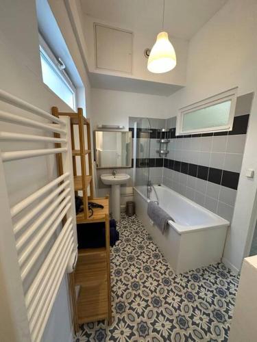 une salle de bain avec une baignoire, des toilettes et un lavabo dans l'établissement Grand appartement Cordier, à Rouen
