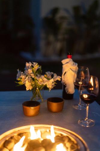 a table with a candle and flowers and wine glasses at Orixás Residence in Morro de São Paulo