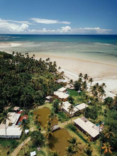 an aerial view of a beach with houses and the ocean at Orixás Residence in Morro de São Paulo