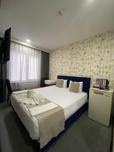 Cette chambre comprend un grand lit et une télévision. dans l'établissement Nostalji Hotel, à Avcılar