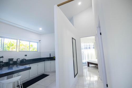a kitchen with white cabinets and black counter tops at Apartamentos Cristal in Quepos
