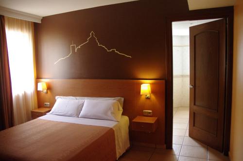 ソルソナにあるHotel Solsona Centreのベッドルーム1室(壁にチャート付きのベッド1台付)