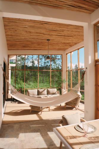 a hammock in a living room with a large window at Hidden Valley Wilderness Lodge in San Ignacio
