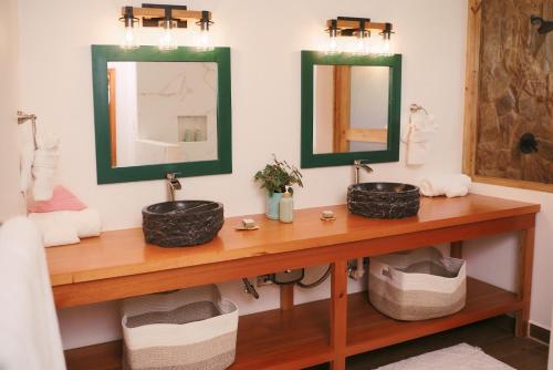 a bathroom with two sinks and two mirrors at Hidden Valley Wilderness Lodge in San Ignacio