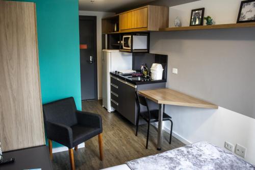 a small kitchen with a table and a chair in a room at Studio no centro de Curitiba in Curitiba