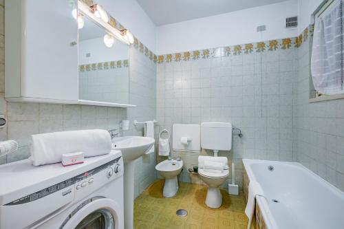 ein Badezimmer mit einem WC, einem Waschbecken und einer Waschmaschine in der Unterkunft Snow White - Happy Rentals in Bardonecchia