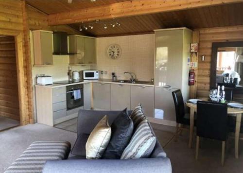 a living room with a couch and a kitchen at Bishops Park Lodges At Fingle Glen Golf Hotel in Exeter