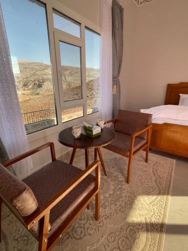 a room with a bed and a table and a window at Jabal Shams, the summit house in Misfāh