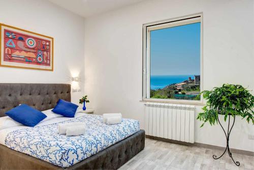 馬薩盧布倫塞的住宿－Casa Felix Renovated apartment whit views，一间卧室设有大窗户和一张带蓝色枕头的床