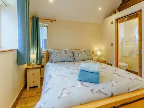 a bedroom with a bed with a blue towel on it at 2 Bed in Usk 87285 in Llandenny