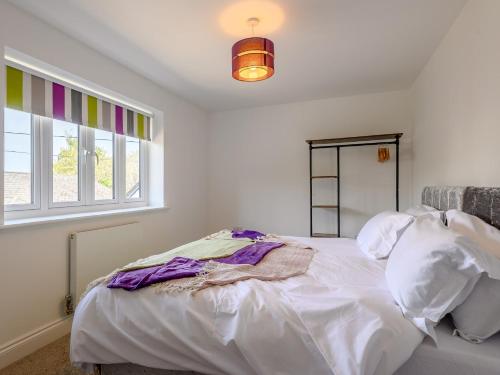 a bedroom with a white bed and a window at 3 bed in Blue Anchor 87069 in Withycombe