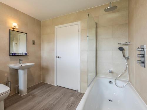 a bathroom with a shower and a tub and a sink at 3 Bed in St. Mellion 87716 in St Mellion