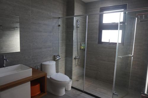 a bathroom with a shower with a toilet and a sink at Double Egg Yolk Living Space in Dongshan