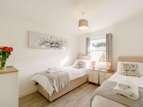 a bedroom with two beds and a window at 2 Bed in Portreath 88826 in Camborne