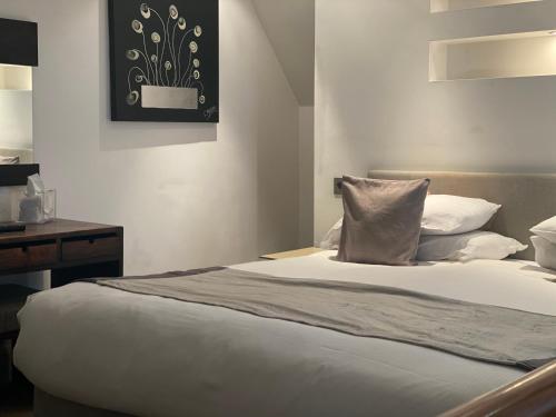 a bedroom with a bed with a pillow and a desk at The Rooms Lytham in Lytham St Annes