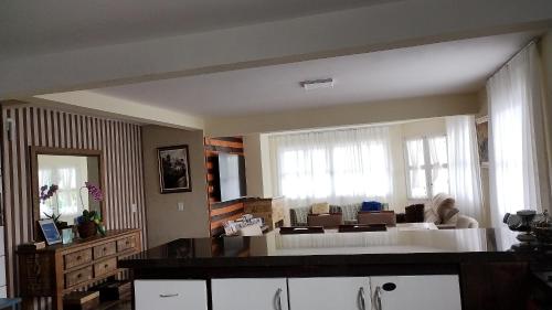 a large living room with a large window and a couch at Recanto da Sol in Florianópolis
