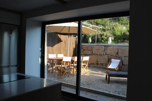 a kitchen with a table and chairs and an umbrella at Casas Velhas in Santo Aleixo de Além Tamega