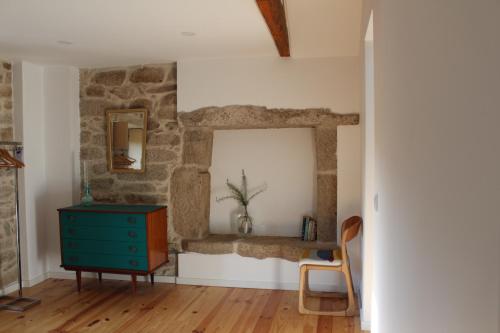 Cette chambre dispose d'une commode bleue et d'un mur en pierre. dans l'établissement Casas Velhas, à Santo Aleixo de Além Tamega
