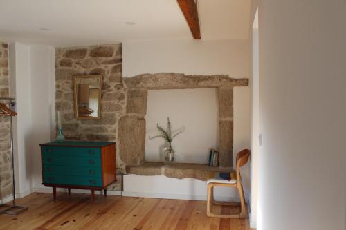 a room with a blue dresser and a stone wall at Casas Velhas in Santo Aleixo de Além Tamega