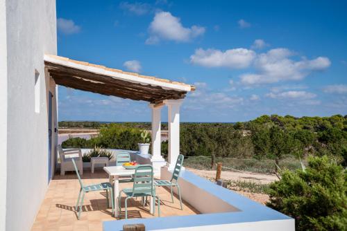 a patio with a table and chairs and a view at Cas Saliners - Parc Natural in La Savina