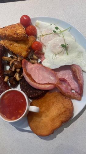 a plate of breakfast food with eggs bacon and toast at The Rooms Lytham in Lytham St Annes