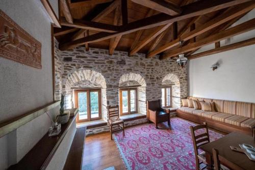 a living room with a couch and some windows at Archontiko Michael Pelion in Vizitsa