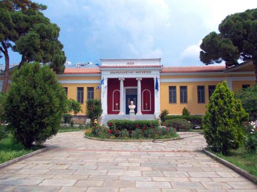 a yellow and red house with a statue in the front at Archontiko Michael Pelion in Vizitsa