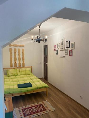 a bedroom with a green bed in a room at Trei Tulnice in Rau Sadului