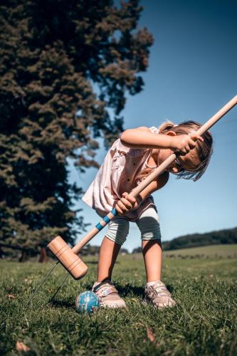 a little girl holding a baseball bat and a ball at Apartmán-Hotel Jítravský Dvorec in Rynoltice