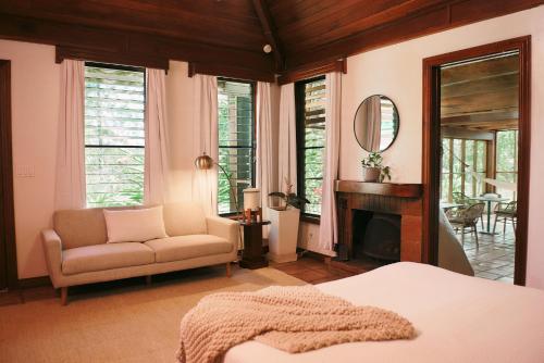 a bedroom with a bed and a chair and a mirror at Hidden Valley Wilderness Lodge in San Ignacio