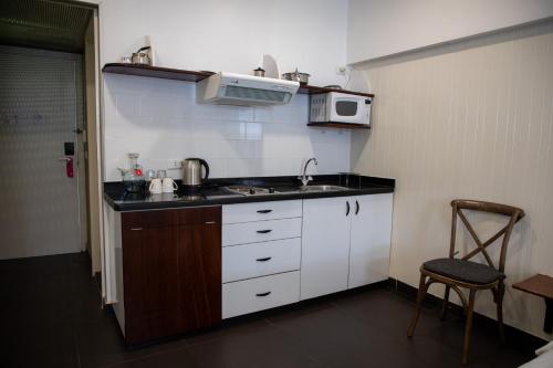 a small kitchen with a sink and a microwave at Hamra Urban Gardens in Beirut