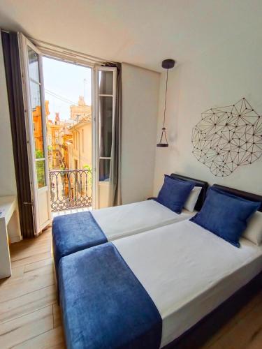 a bedroom with two beds and a large window at Hotel El Siglo in Valencia