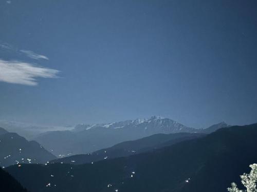 a view of a valley with mountains in the distance at Himalayan Canvas khajjiar in Khajjiar 