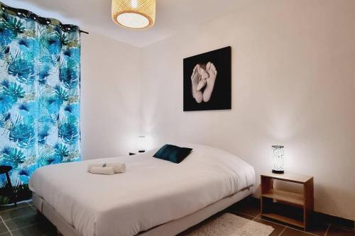 una camera da letto con un grande letto bianco e una finestra di *l'Oasis du Cœur de Ville*Spacieux et moderne a Gravelines