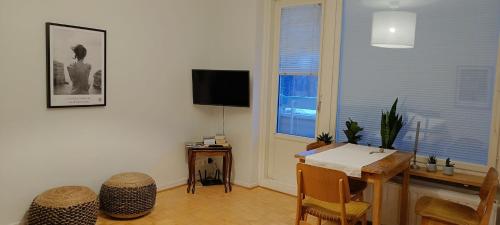 sala de estar con mesa y TV en Cozy renovated flat in Kajaani center (alv. vähennyskelpoinen), en Kajaani