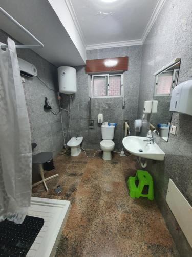 a dirty bathroom with two toilets and a sink at Hospedagem Emanuel in Caneças