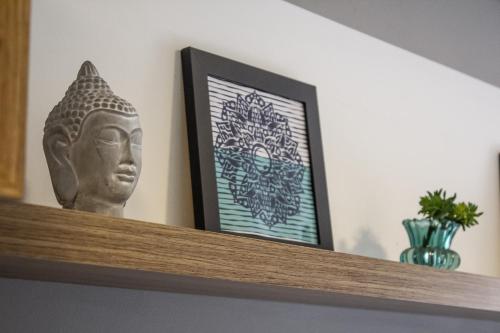 a statue sitting on a shelf with a picture at Studio no centro de Curitiba in Curitiba