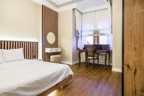 1 dormitorio con cama, escritorio y mesa en Chic Flat 10 min to Goldenhorn in Fatih, en Estambul