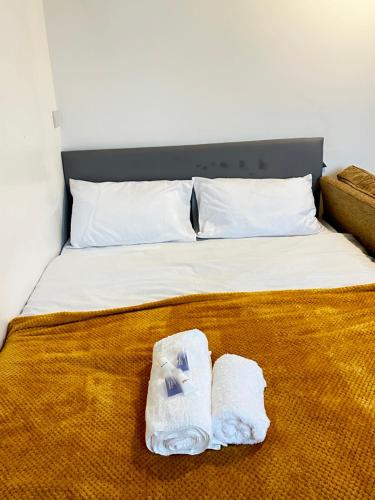 a bed with two towels and a robe on it at Ebehi Inn in London