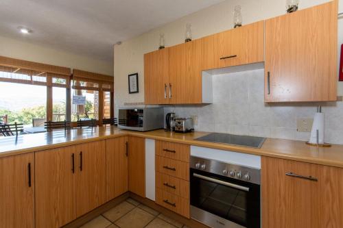 a kitchen with wooden cabinets and a stove top oven at Kruger Park Lodge Unit No. 516 in Hazyview