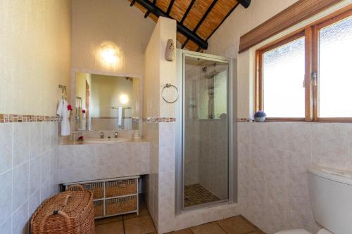 uma casa de banho com um chuveiro e um lavatório. em Kruger Park Lodge Unit No. 516 em Hazyview