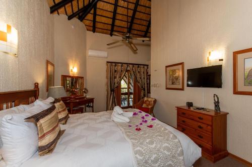 a bedroom with a large white bed with flowers on it at Kruger Park Lodge Unit No. 516 in Hazyview