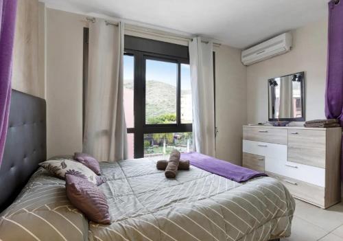 a bedroom with a bed with pillows and a window at LOVE ISLAND 77 in Palm-mar