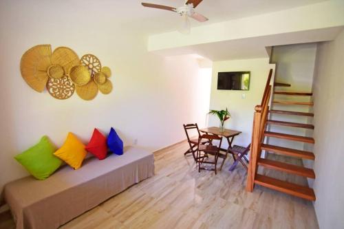 een woonkamer met een bank met kleurrijke kussens en een tafel bij Casa Ramildes Paraty flat 5 in Paraty