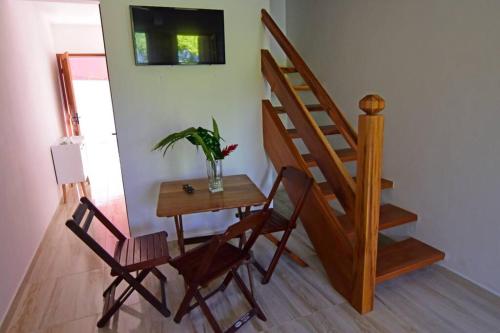 een kamer met een tafel en stoelen en een trap bij Casa Ramildes Paraty flat 5 in Paraty