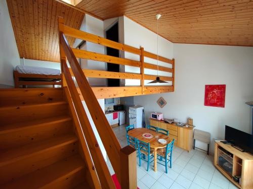 une pièce avec un escalier et une table et une cuisine dans l'établissement Maison cosy à 700 m de l'océan, à Bretignolles-sur-Mer