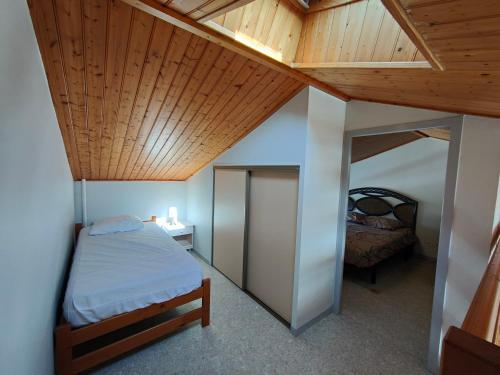 une chambre avec un lit et un plafond en bois dans l'établissement Maison cosy à 700 m de l'océan, à Bretignolles-sur-Mer
