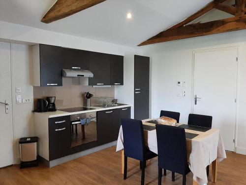 - une cuisine avec une table et des chaises bleues dans la chambre dans l'établissement La Mariennaye, à Beaurepaire