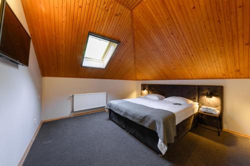 a bedroom with a large bed with a wooden ceiling at Voevodyno Resort in Tur'ya Pasika